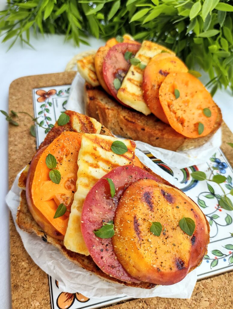 Wegetariański grill - grzanka z halloumi, brzoskwiniami BBQ i pomidorami.